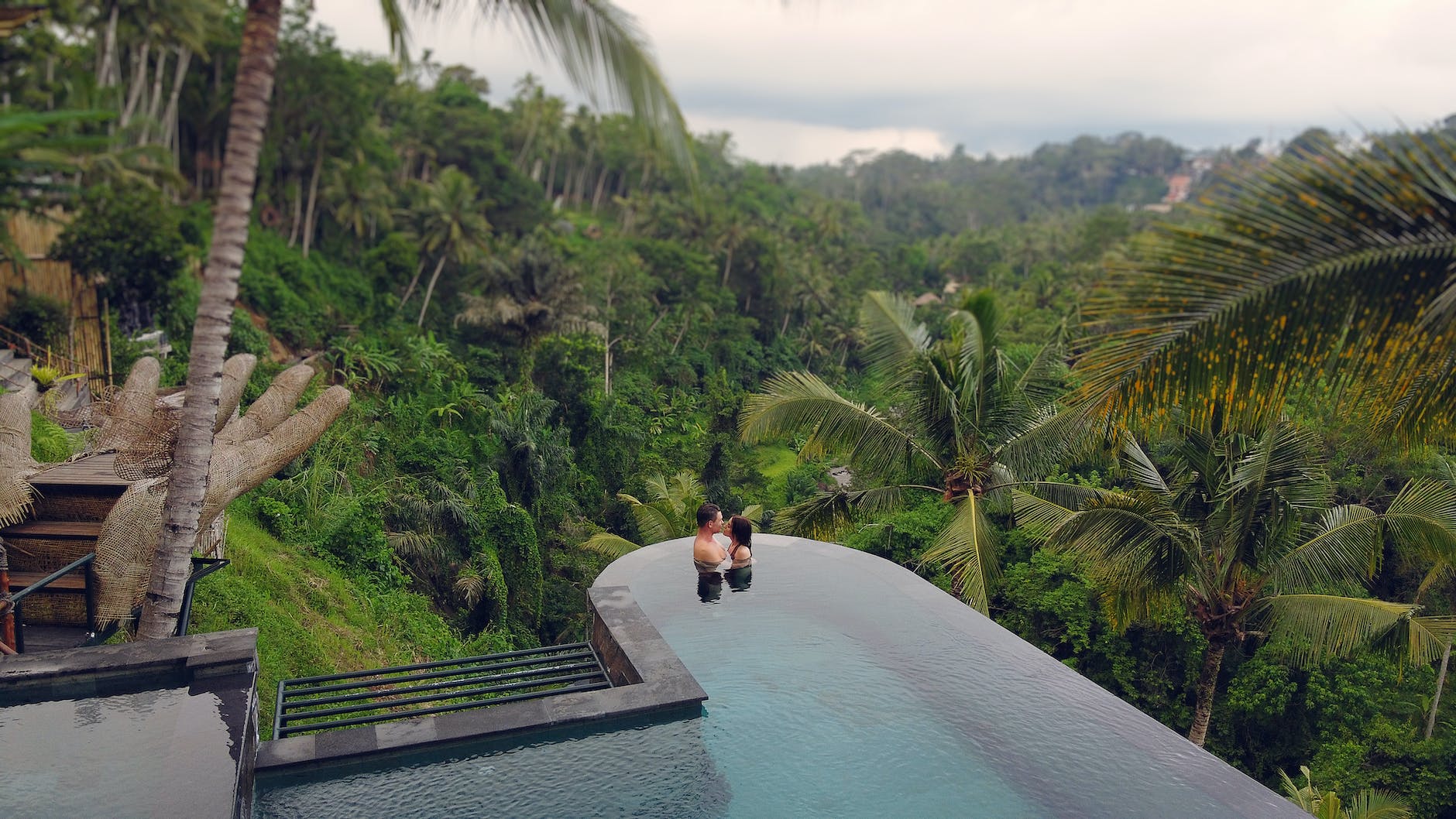 loving couple chilling in swimming pool in tropical resort